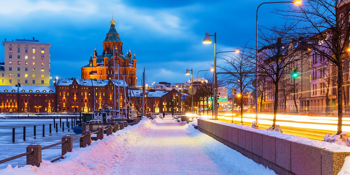 Photographie hivernale d'une ville la nuit, couverte de neige.