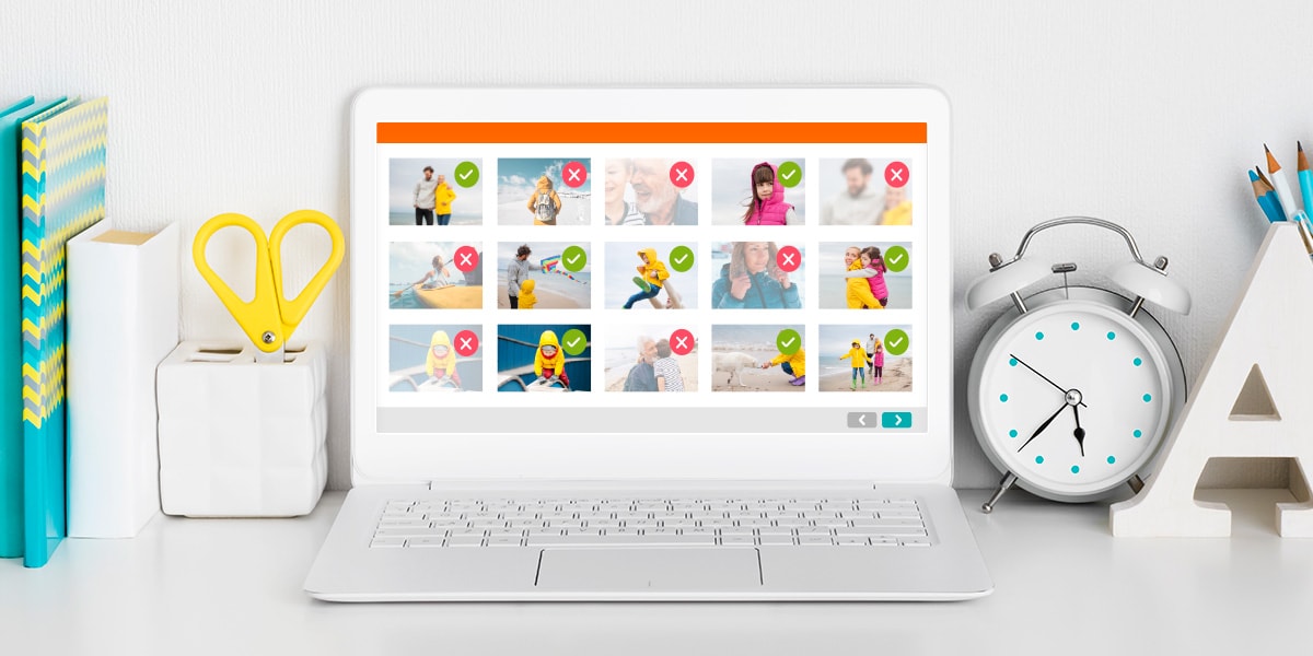 Un ordinateur portable blanc avec le programme Smart Assistant à l'écran, posé sur un bureau et entouré d'un réveil blanc et de fournitures de bureau colorées.