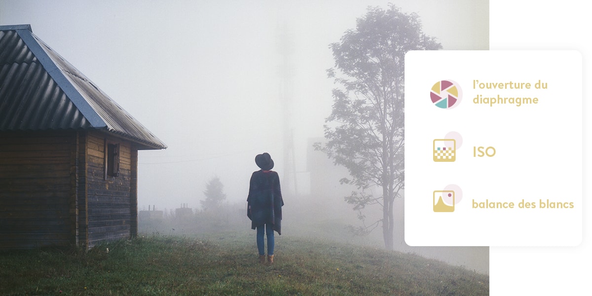 Femme debout à l'extérieur, dos à l'appareil photo. La photo étant très brumeuse, une partie de l'arrière-plan est floue.