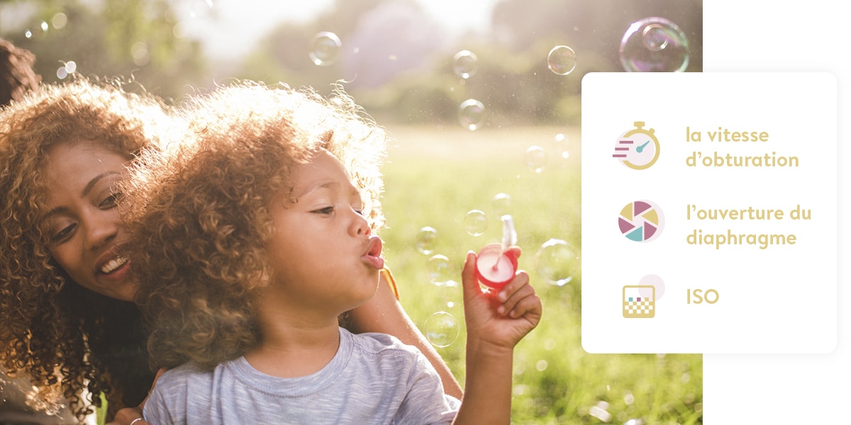 Femme et jeune garçon faisant des bulles de savon dans un parc par beau temps.