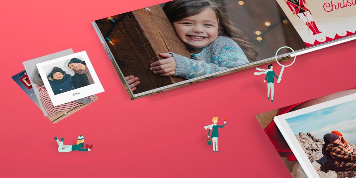 Twee fotoboeken met kersttaferelen, een kleine stapel fotoafdrukken en een groep geïllustreerde personages tegen een rode achtergrond.