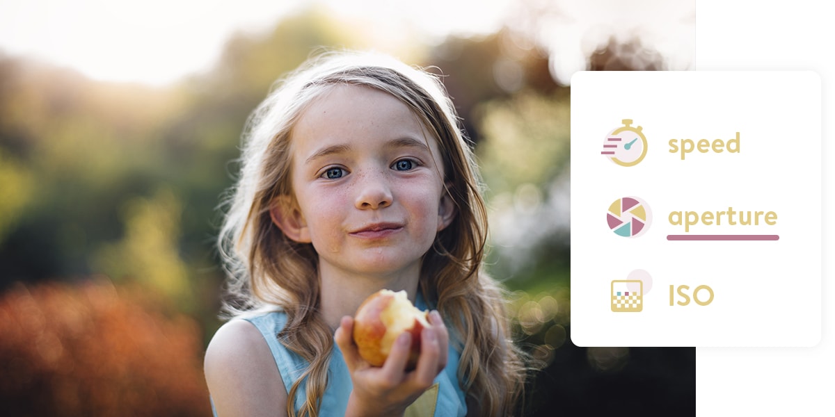 A small girl holding an apple. The foreground is in focus, the background is blurry.