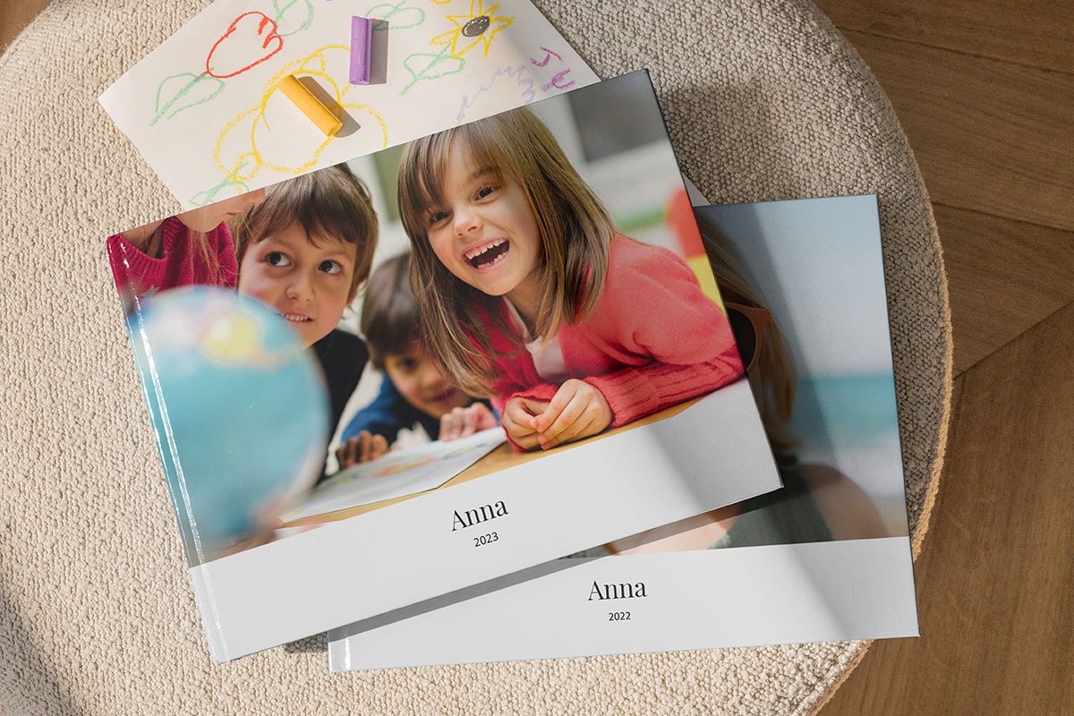 Two photo books on top of each other, the top one displaying a child's school photo book