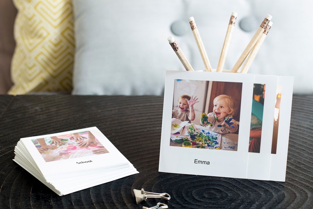 A selection of retro-style photo prints showing little kids at nursery school painting.