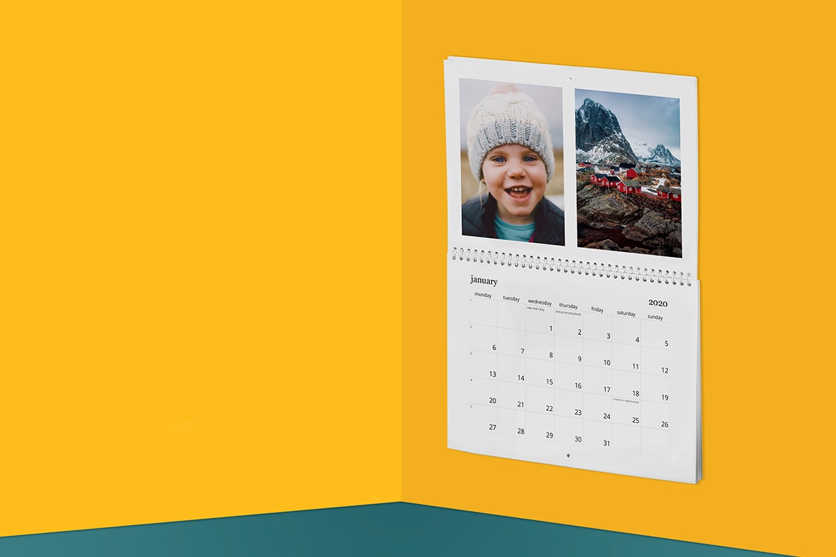 A photo calendar on a yellow wall showing a young child in a wooly hat