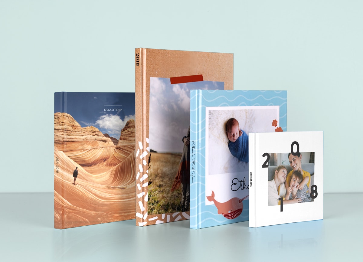 four photo books in a mixture of sizes and formats, ranging from baby books to travel books.