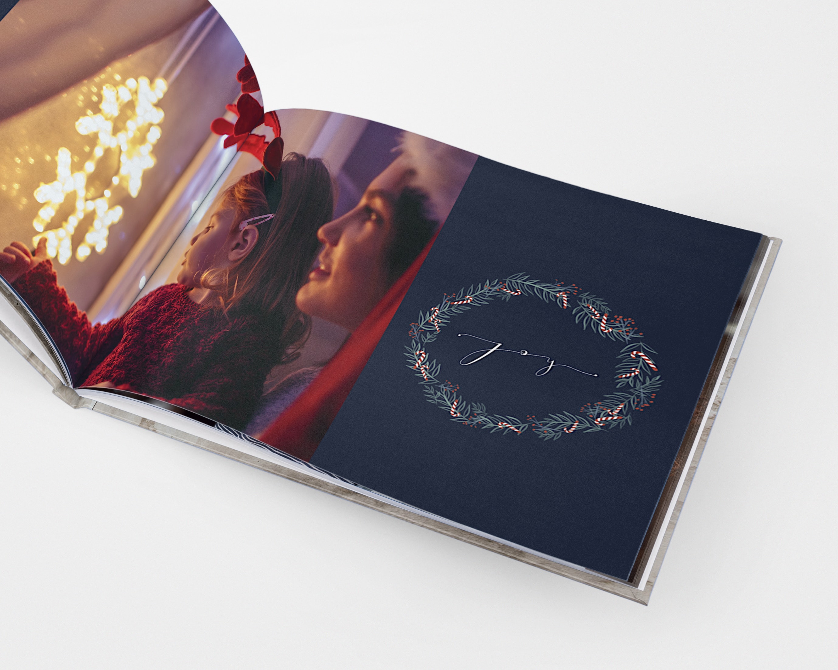 Ein weihnachtliches Fotobuch mit festlichen Zeichnungen und einem Bild einer Mutter und einer Tochter, die die Weihnachtsbeleuchtung bestaunen