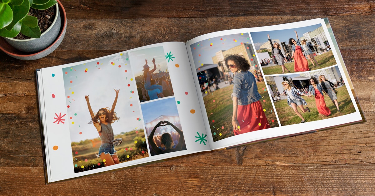 A photo book open on a double page, showing photos from a festival. The pages are decorated with confetti clip art.