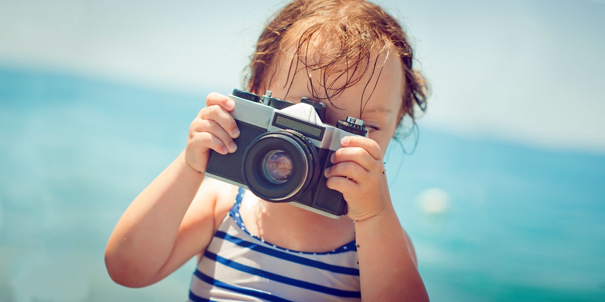 Een foto van een klein kind dat een foto maakt op het strand.