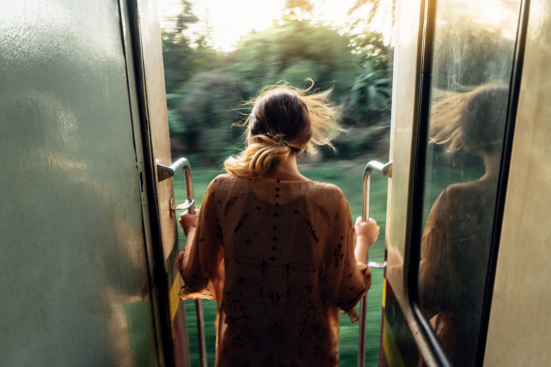 Afbeelding van een meisje dat uit een snel rijdende trein kijkt met een wazige achtergrond