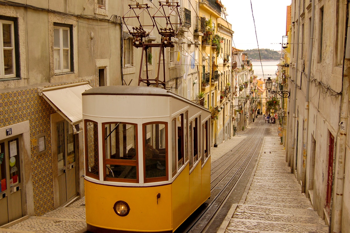 Een foto van een tram in Lissabon op een zonnige dag.
