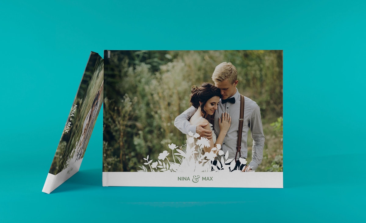 Een trouwalbum met een kaft met foto tegen een lichtblauwe achtergrond.
