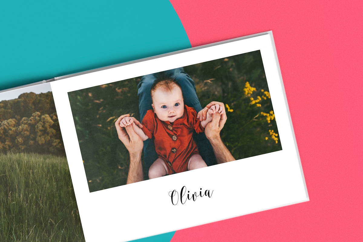 Een persoon die door een roze babyboek bladert met wit en zwarte foto's erin en een tekst onderaan. Aan de bovenkant van de afbeelding is een tekstvaksymbool aangebracht.