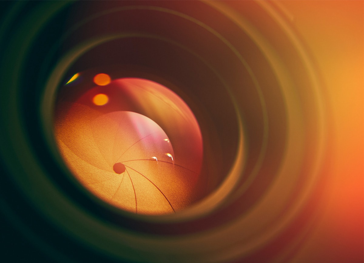 Ett närbildsfoto av en kameralins som visar diafragman i linsen när den stängs.