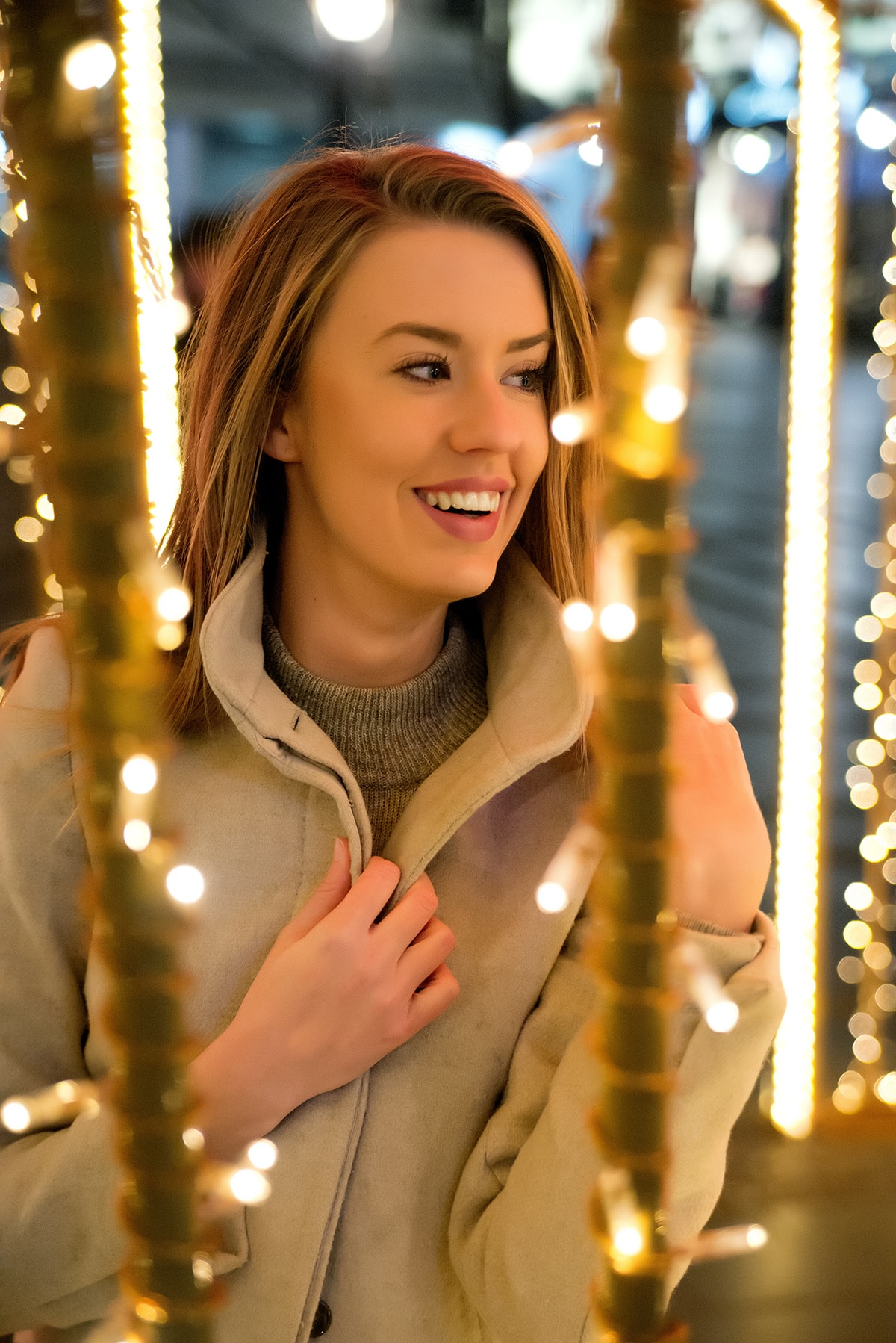 Street portrait of young happy woman on the festive Christmas market at night