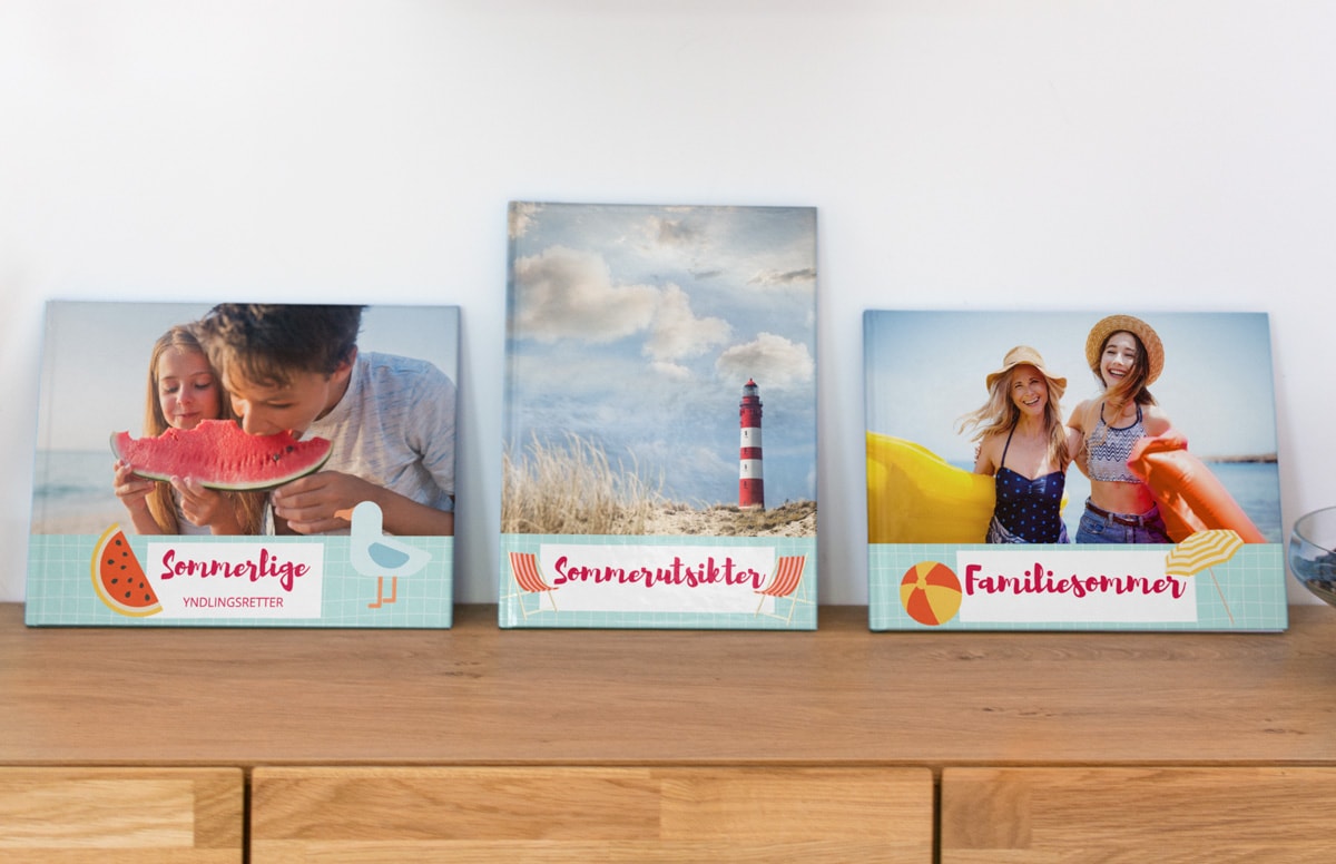 Tre matchende fotobøker med samme type bildeomslag, hver av dem basert på et eget tema; mat, landskaper og familiebilder.
