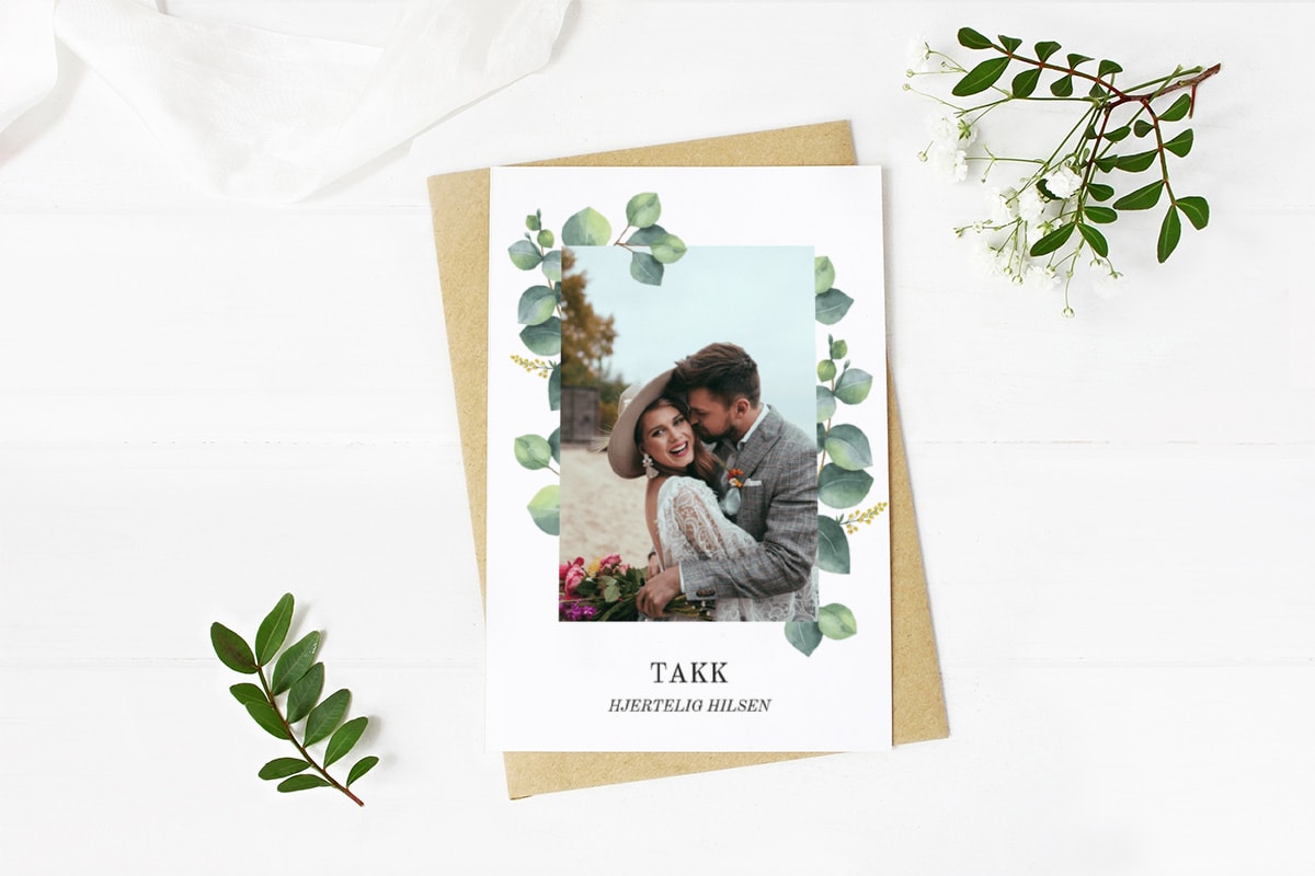 Bryllupskort med grønne planter og foto.