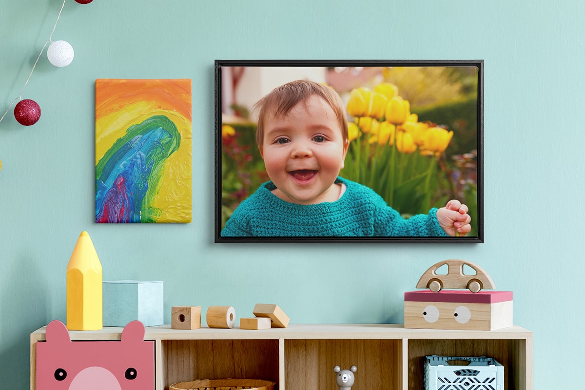 Lifestyle shot of brightly coloured family room, with a hanging decoration, kids' toys on a cabinet, and two canvas wall art images hanging on the wall.